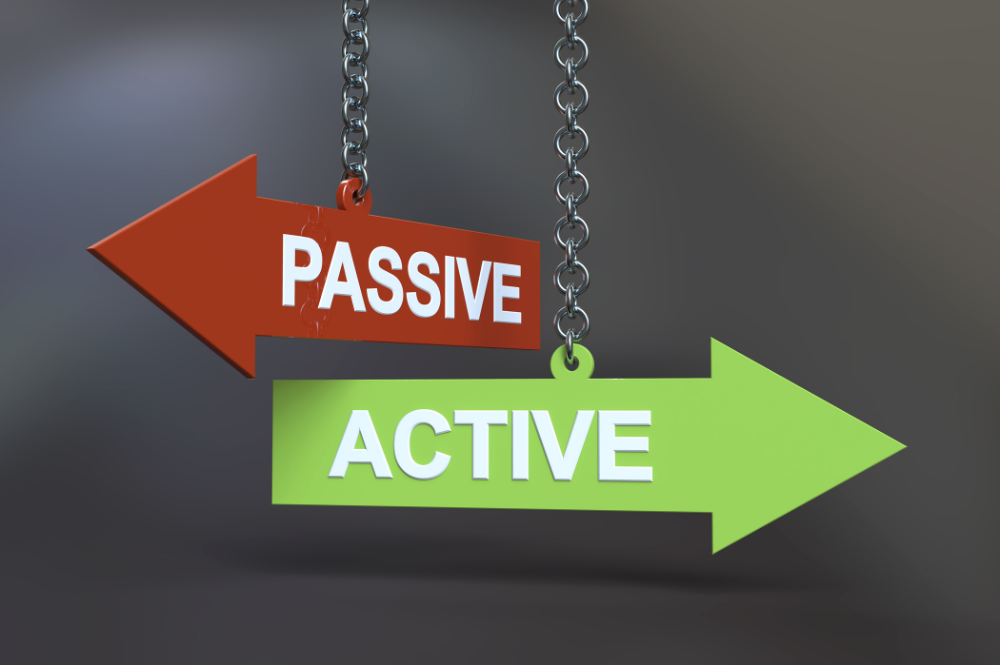 Two signs hanging from chains, one labeled "Active" and the other "Passive," illustrating active vs passive investing.