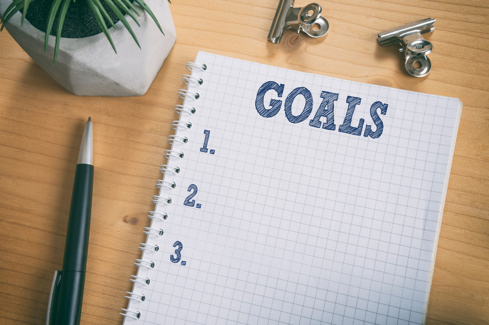 Goals written on a notepad on a desk, emphasizing life goal-based financial planning.