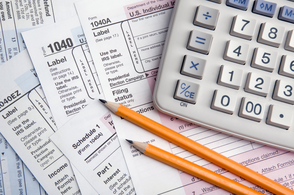 A calculator and tax documents on a desk, symbolizing year-end tax planning and financial organization
