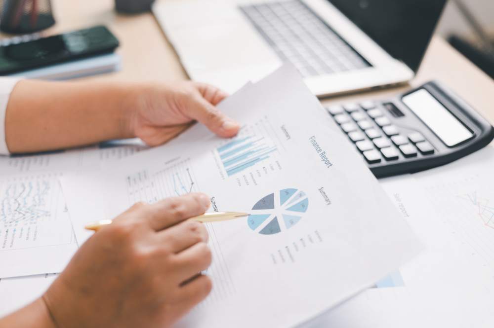 Businessman's hands holding papers and a pen on a desk, emphasizing why financial planning is important.